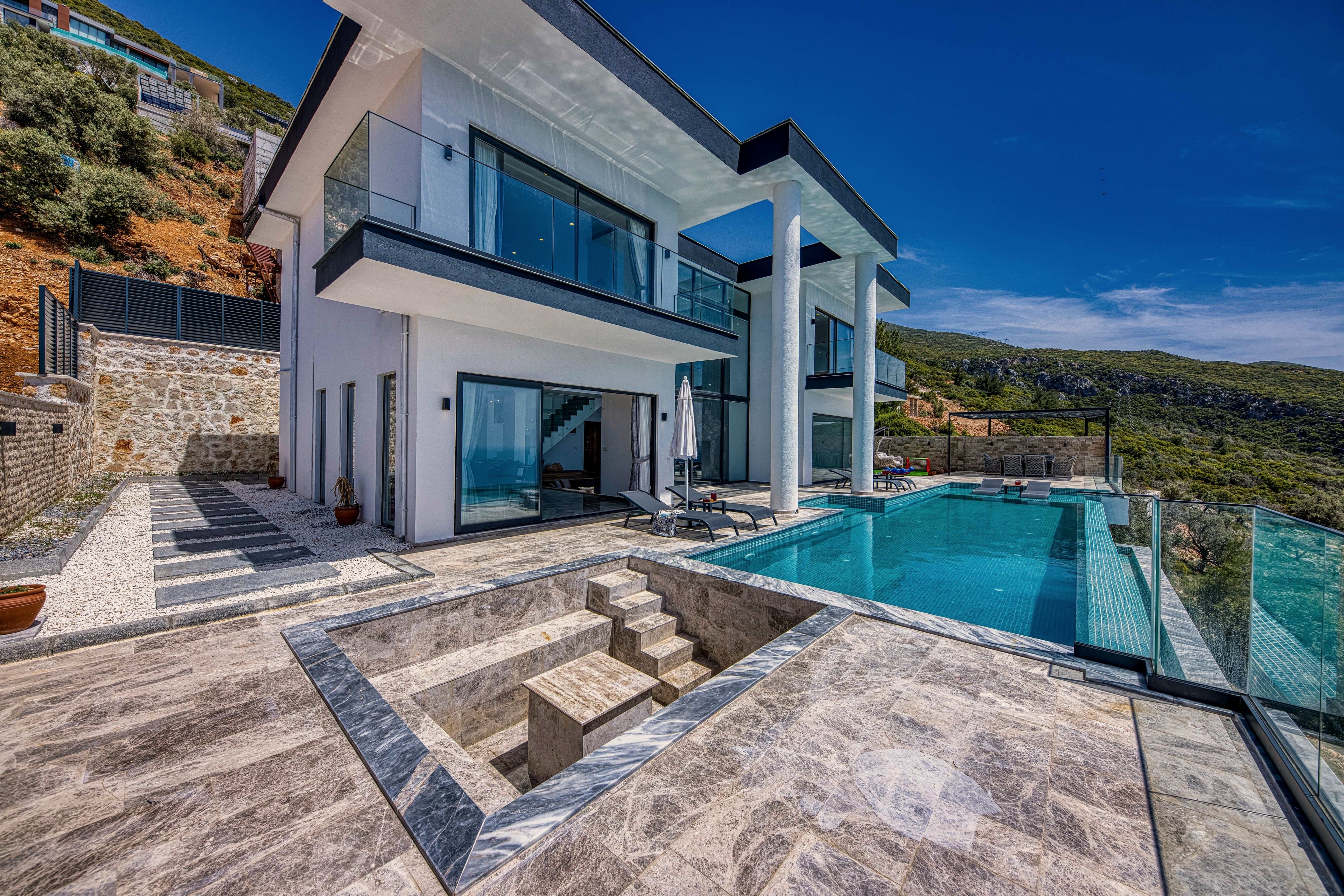 The marble villa and its pool, cut into the hillside