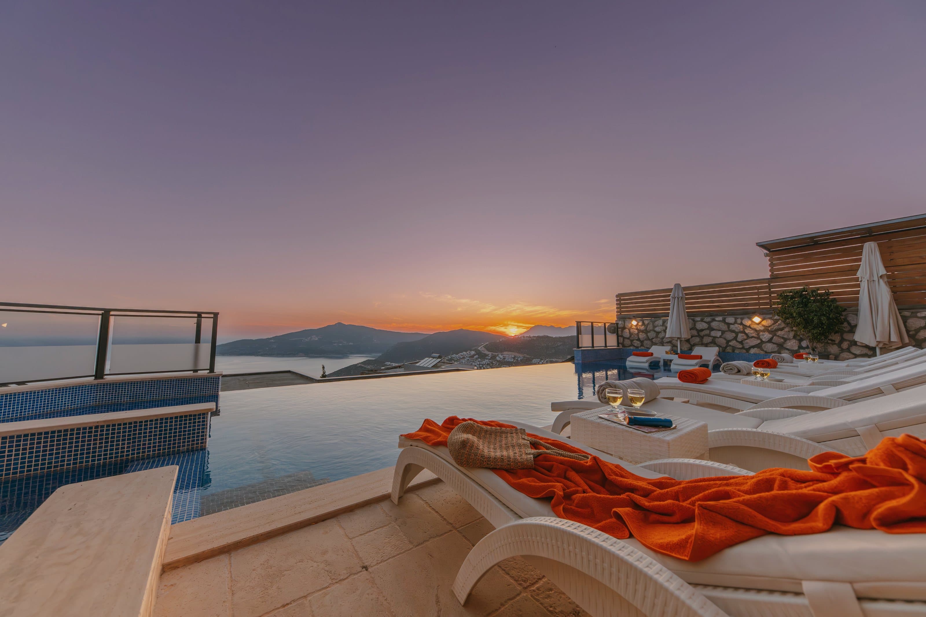 Loungers by the pool edge at sunset