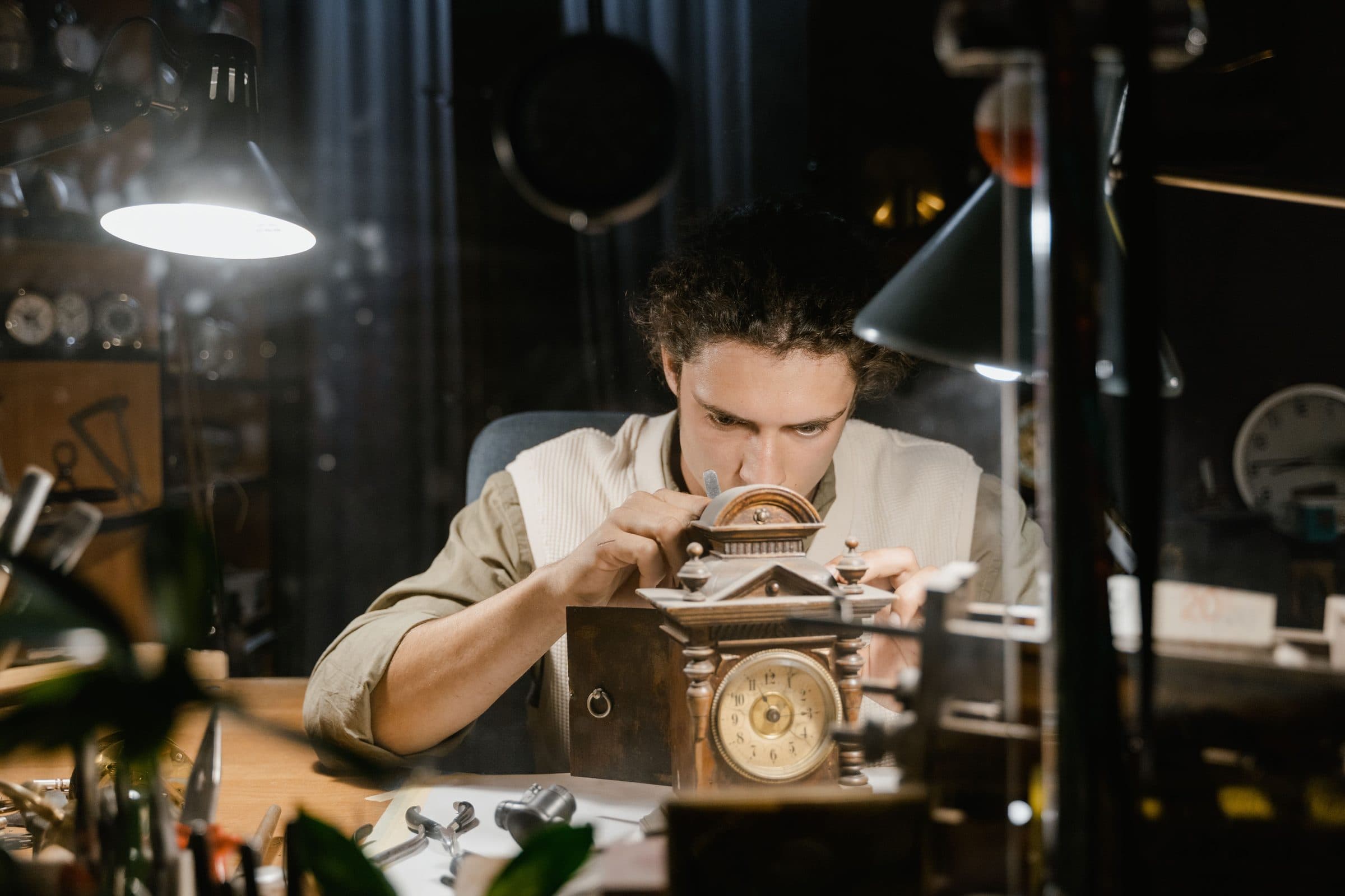 A watchmaker at the bench, bent over a movement